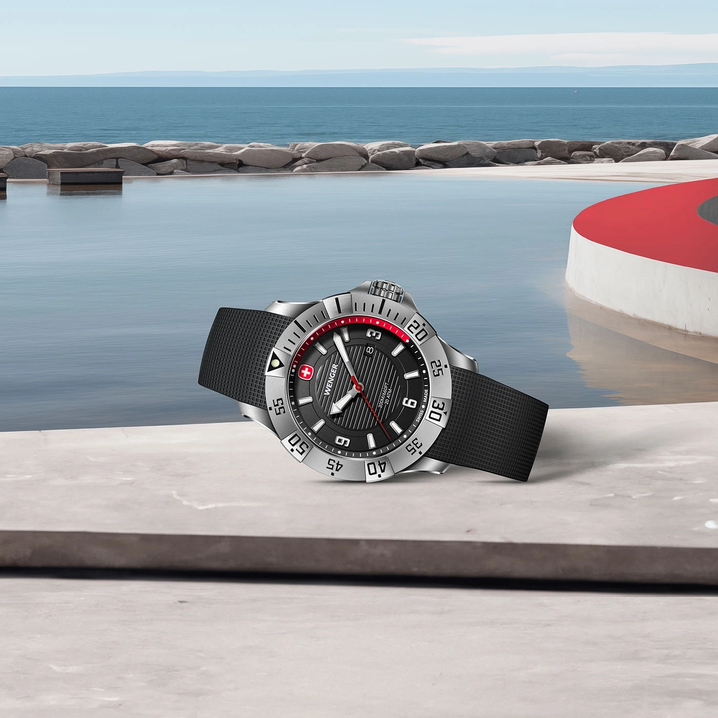 Watch by the pool. Black dial, silver case, red accent, black strap. Wenger watch.