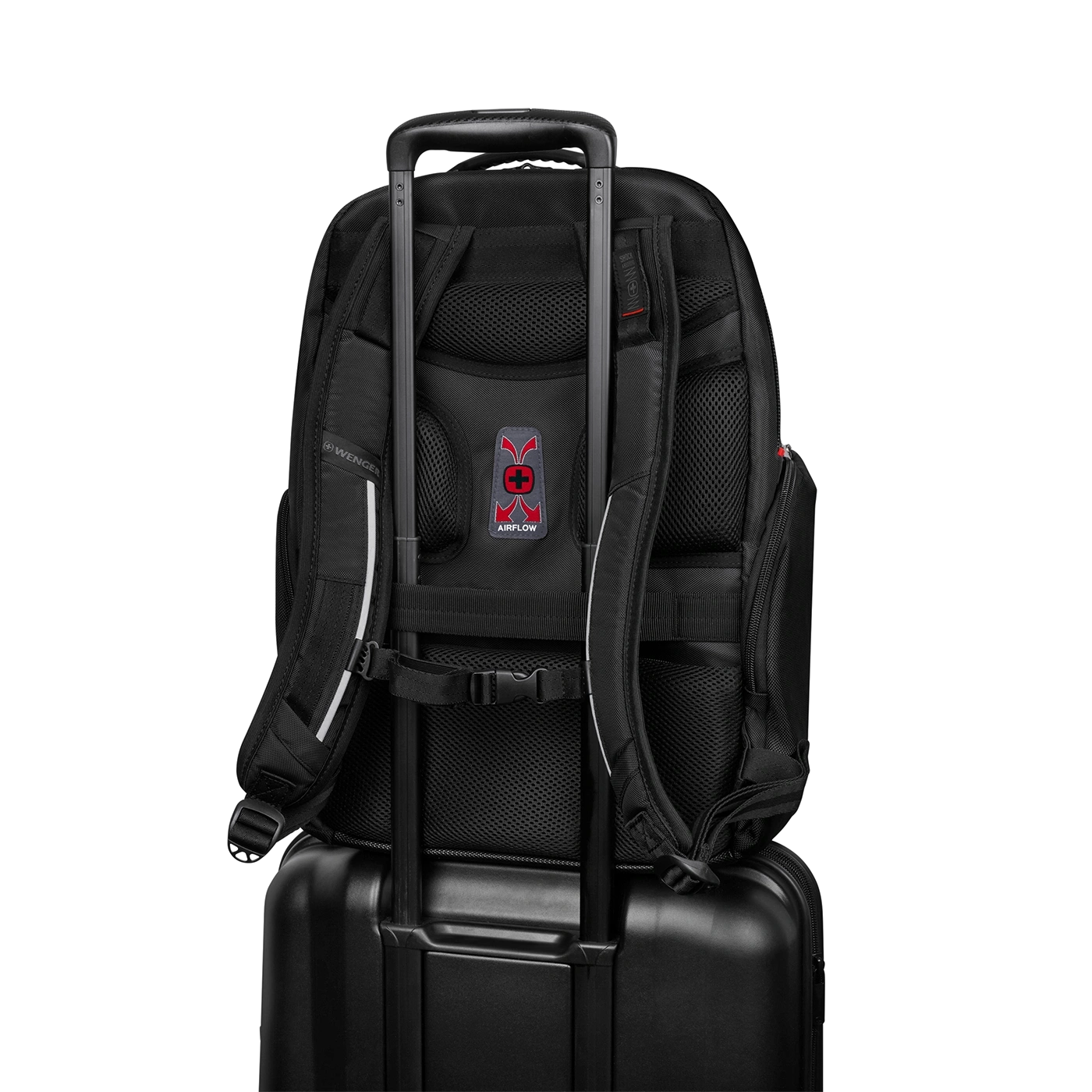 Black backpack on a suitcase with airflow system and Wenger logo on black background.