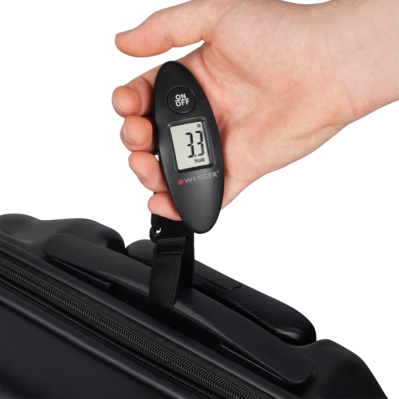 Hand holding luggage scale showing 3.3 lbs, with a black suitcase in the background.